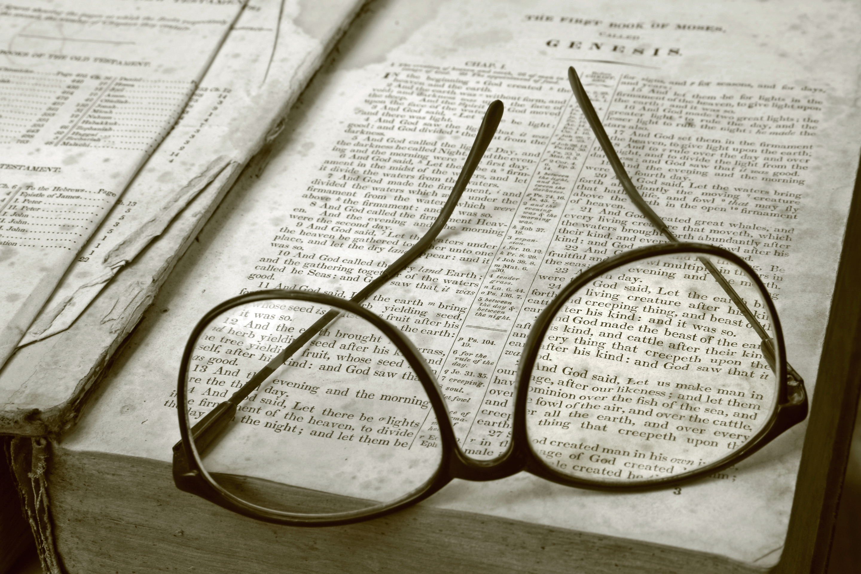 Glasses on The Bible, open to Genesis