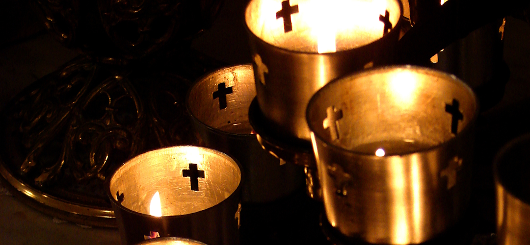 Candles_Banner Brass Votive Candle holder with four filled slots, each with a lit candle within.