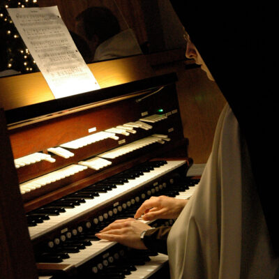 Sister sitting at a piano.
