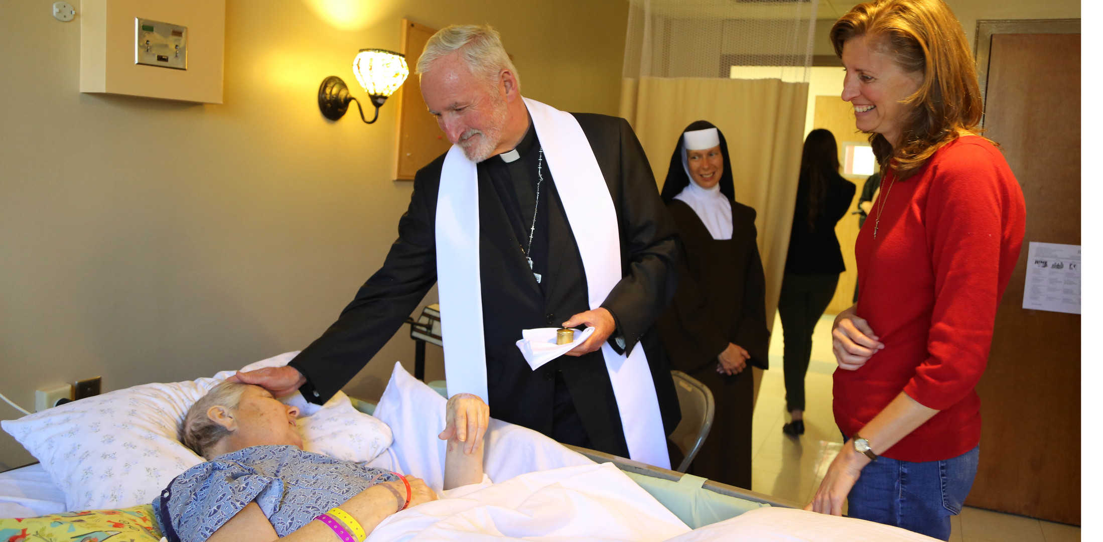 st_bishop Bishop Dave OConnell annointing the sick with a Sister and lay person in the room