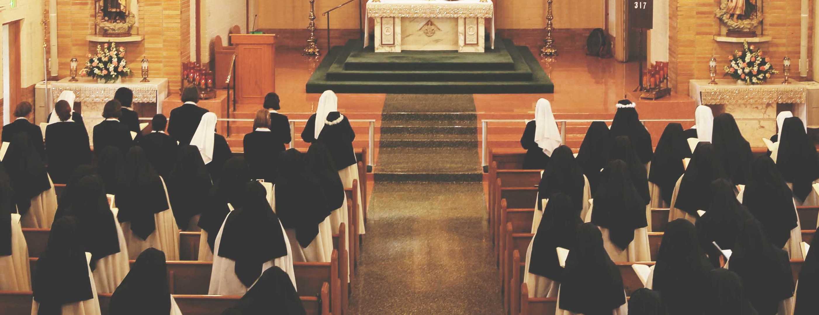community of carmelites in pews facing altar during mass