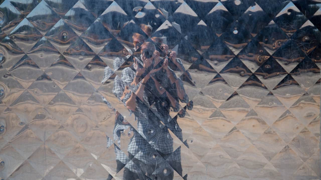 distorted reflection of man with a camera