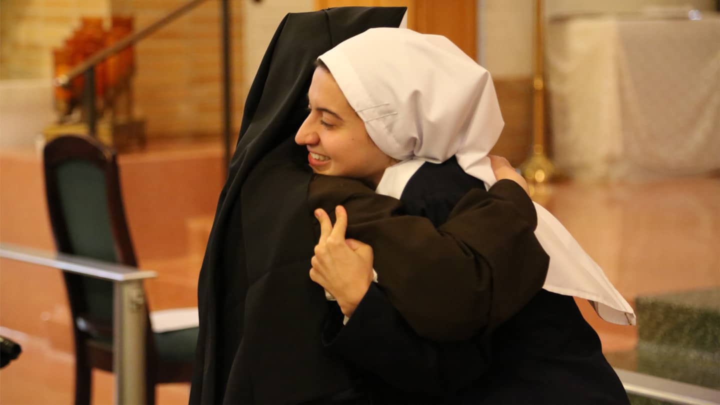 SrCeciliaMarie Sr. Cecilia Marie hugging another in the Chapel