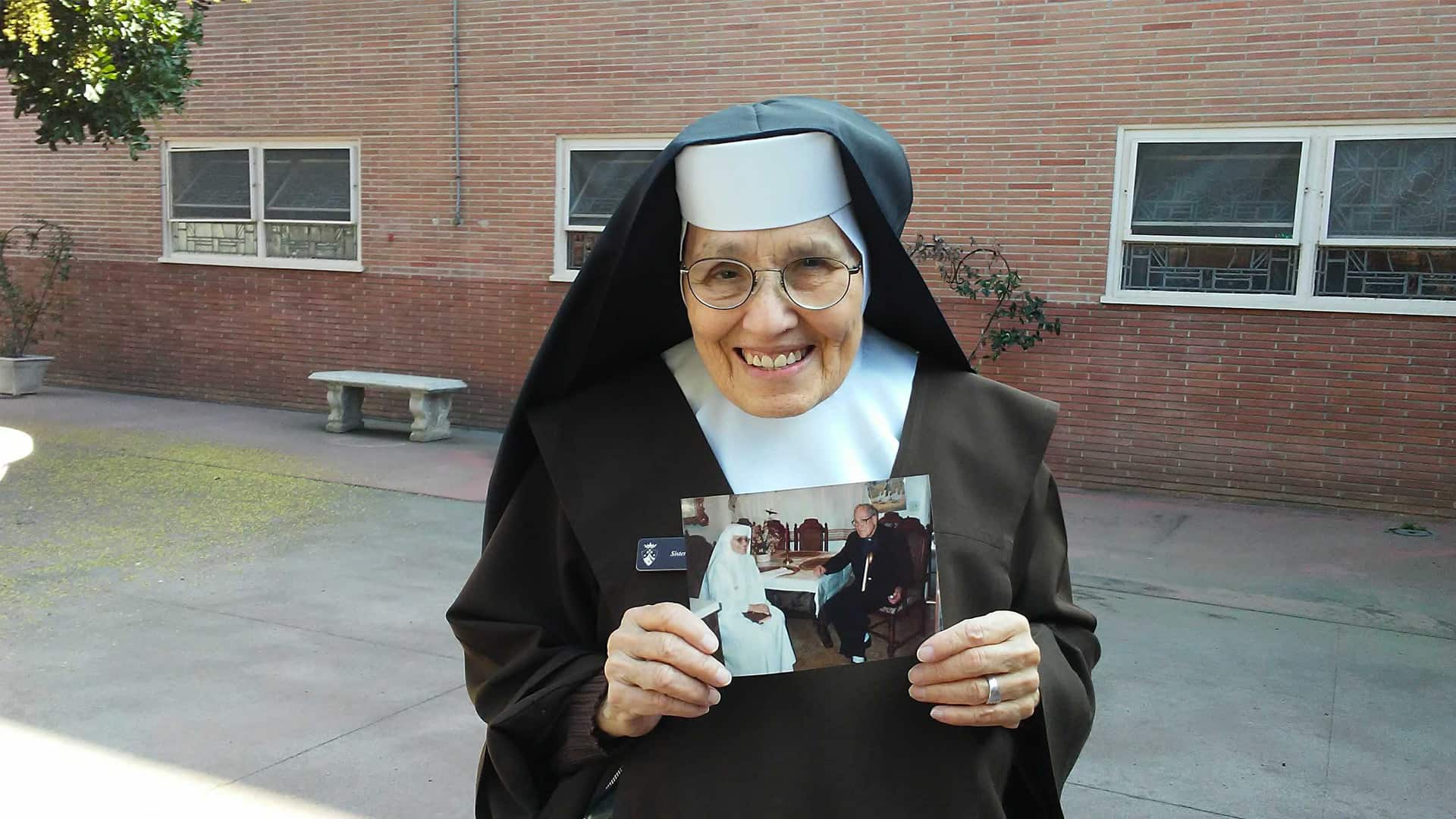 Sr. Elia holding a photo of Fr. Joule