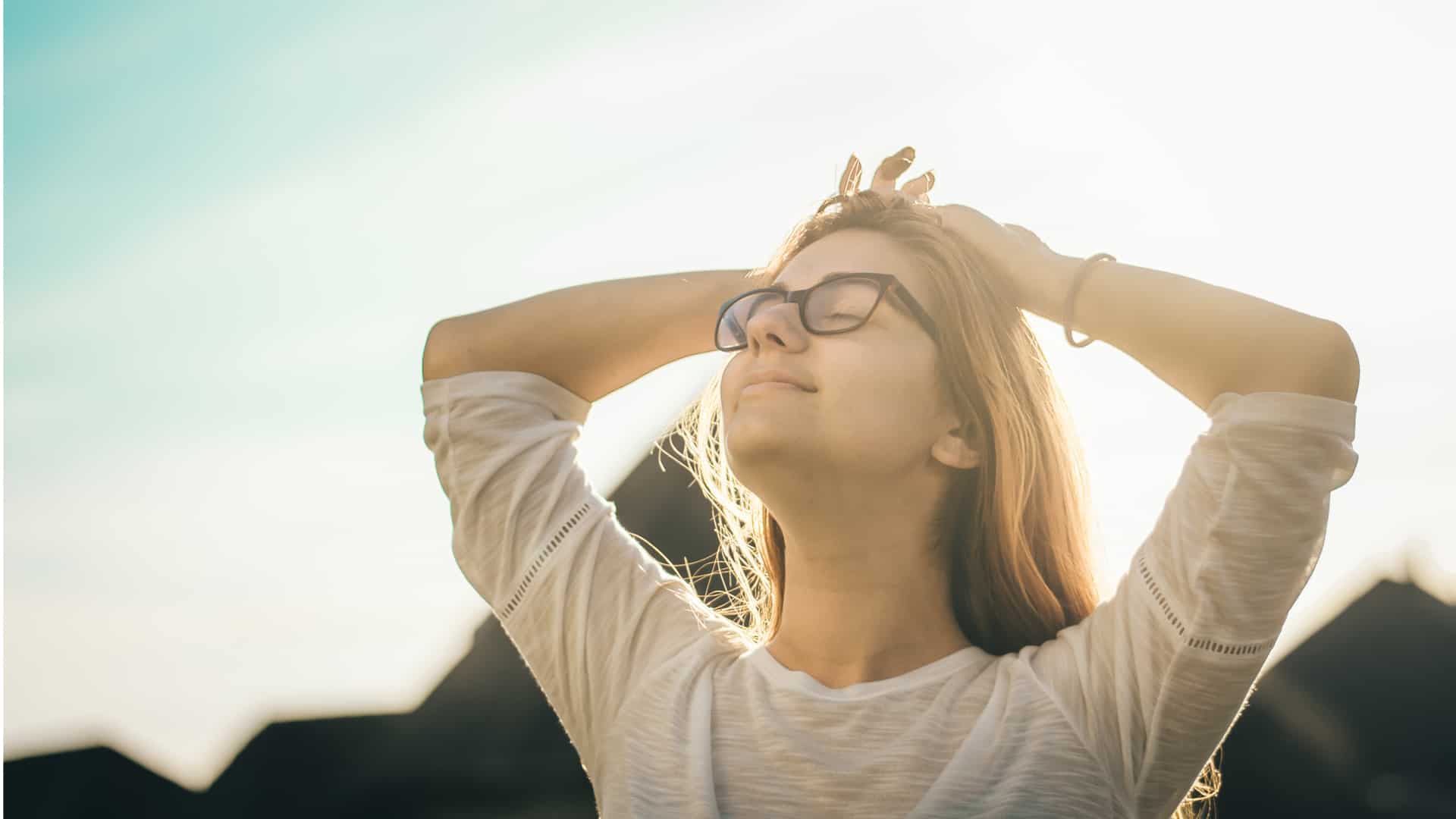 woman realaxing, stretching arms in nature