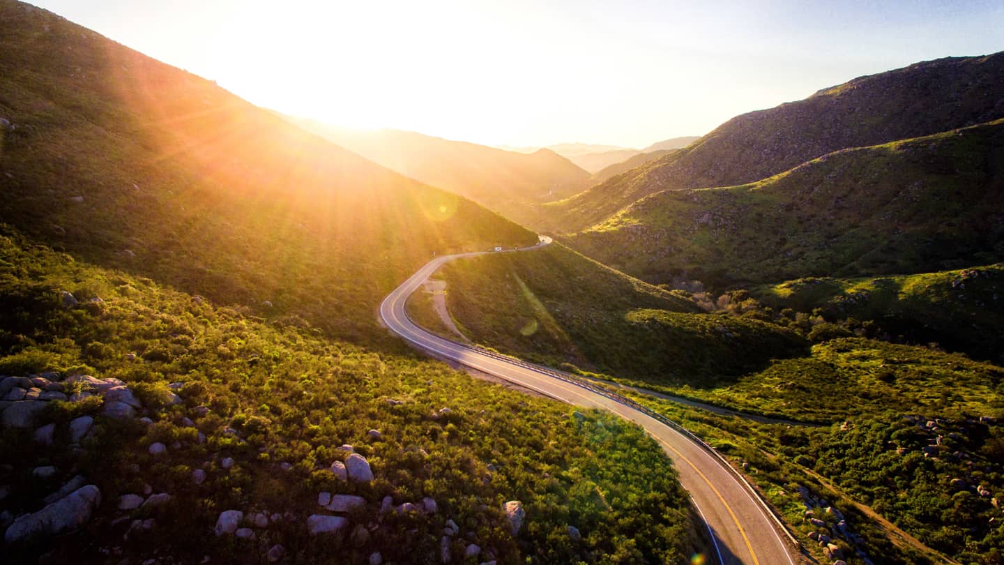 Road_1440 windy road in valley of mountains with sunrise