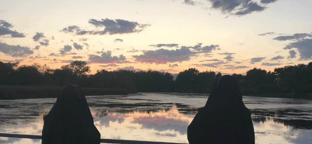 2 sisters looking at a lake and sunset