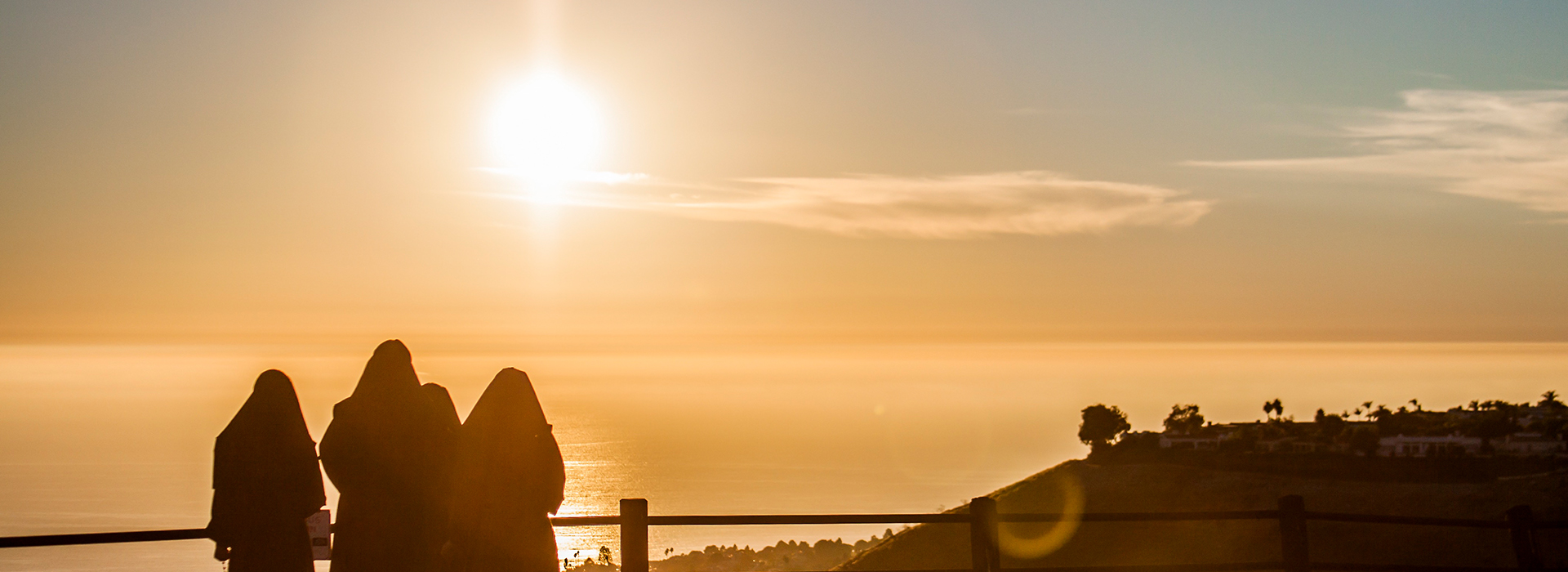 group of sisters watching sunset over beach