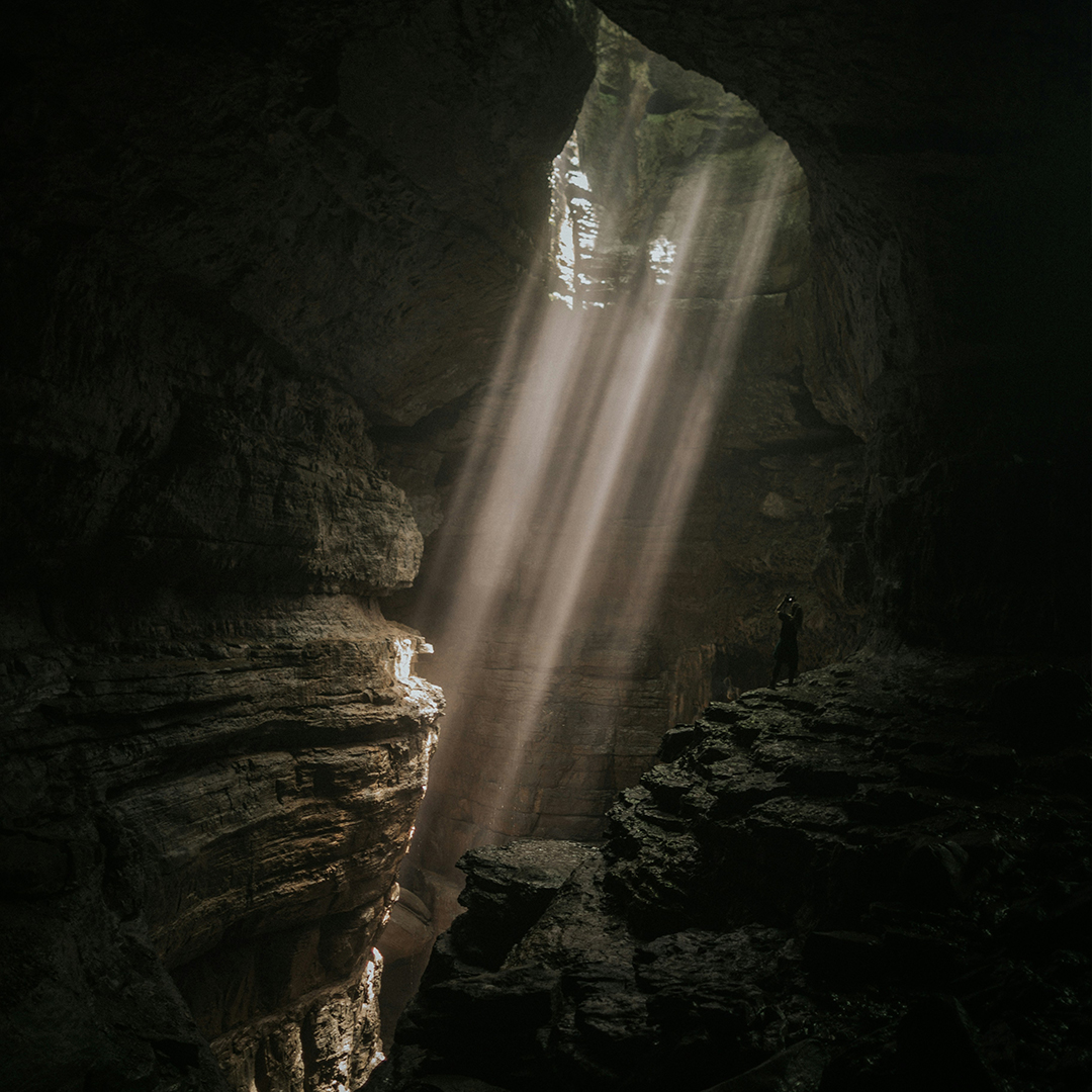 A shaft of light coming through a hole in the ceiling of a cave.