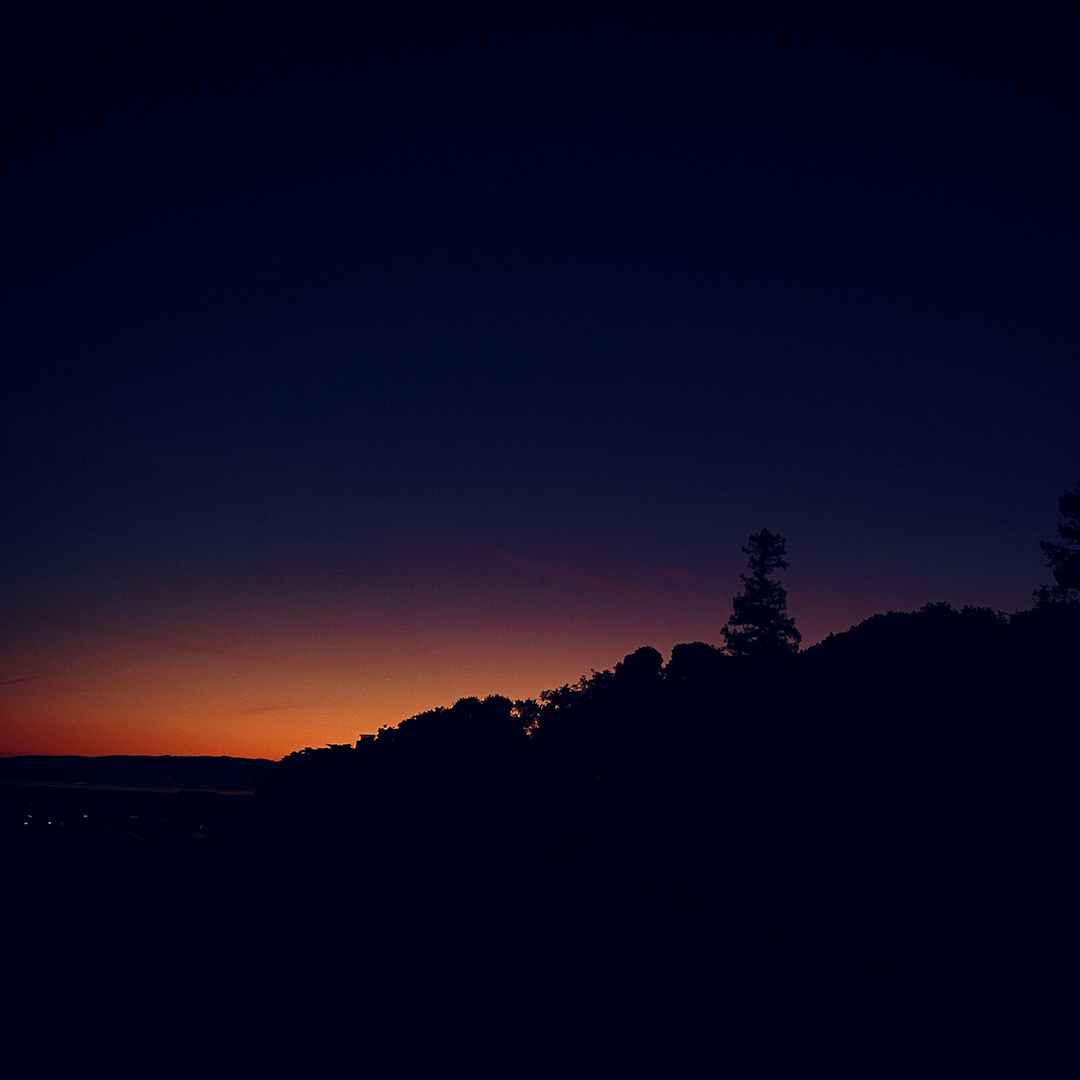 The horizon at sunset, the last light of the sun glowing orange.