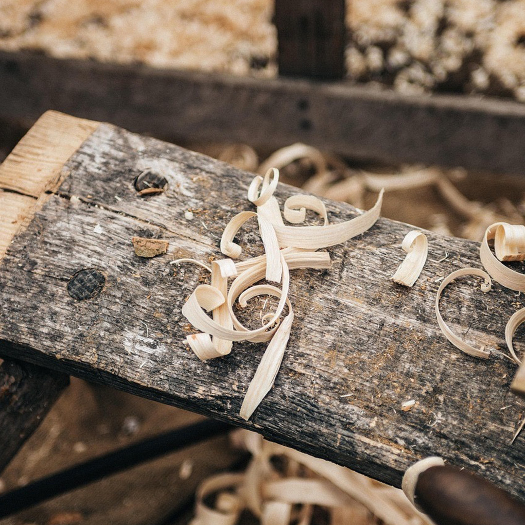 A bench in a woodworking area. Wood shavings litter the area.