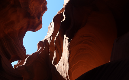 A thin crack of sky is seen from within a sandstone crevice.