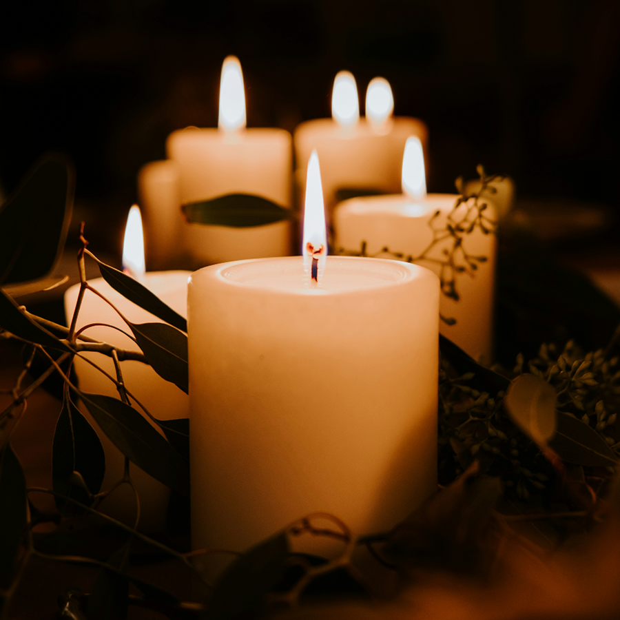 Five lit candles in a rough row, each slightly more out of focus.