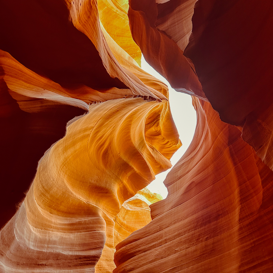 A man holds up a large boulder by himself.