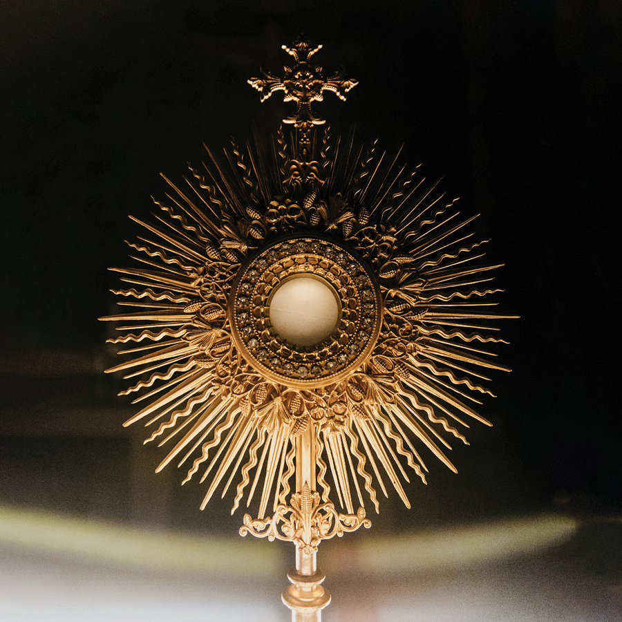 Close up view of a monstrance. It is lit from below.