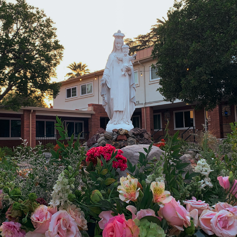 Statue of Mary on the Retreat House grounds. Flowers are laid at her feet.