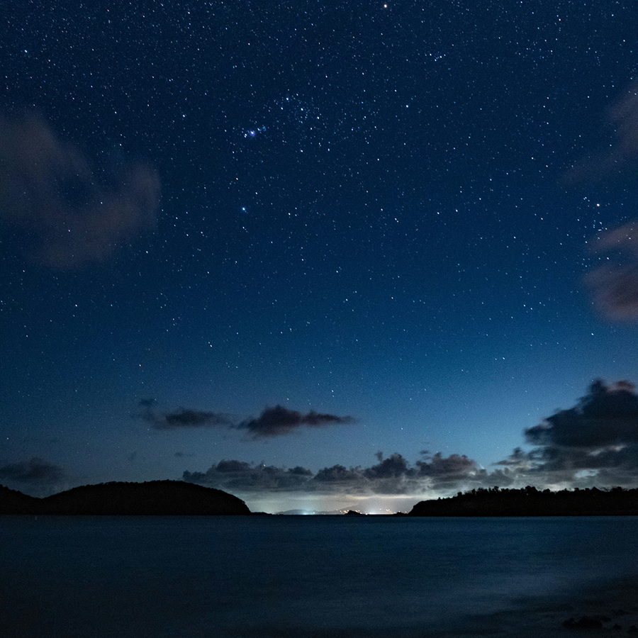 Sunset over a beach. The sky is deep blue.
