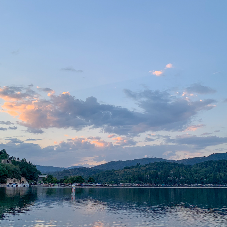 Peaceful lake view with a bright blue sky at dawn.